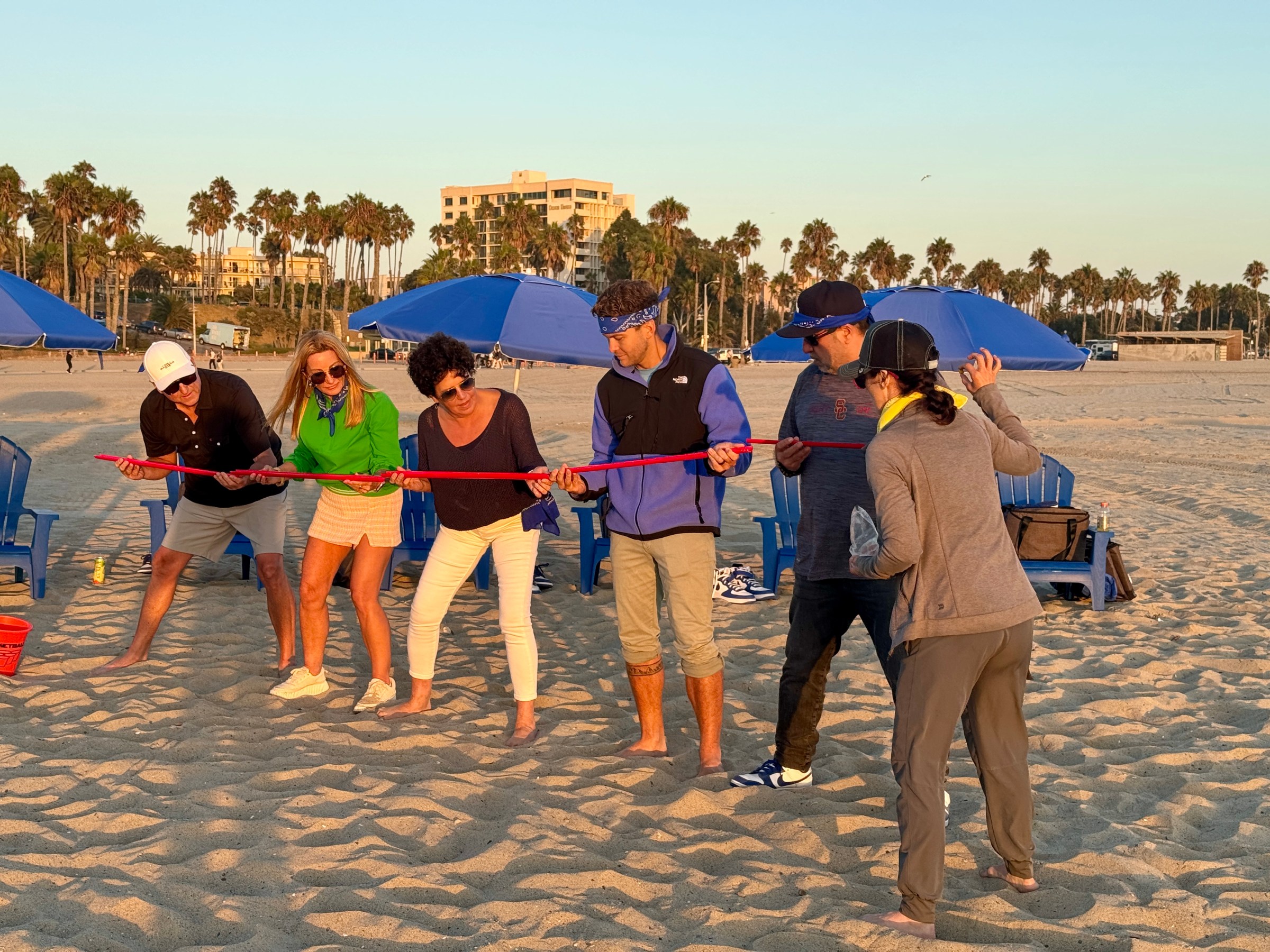 a group of people standing on top of a sandy beach
