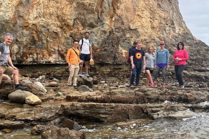 a group of people standing in a rocky area on a group walking tour