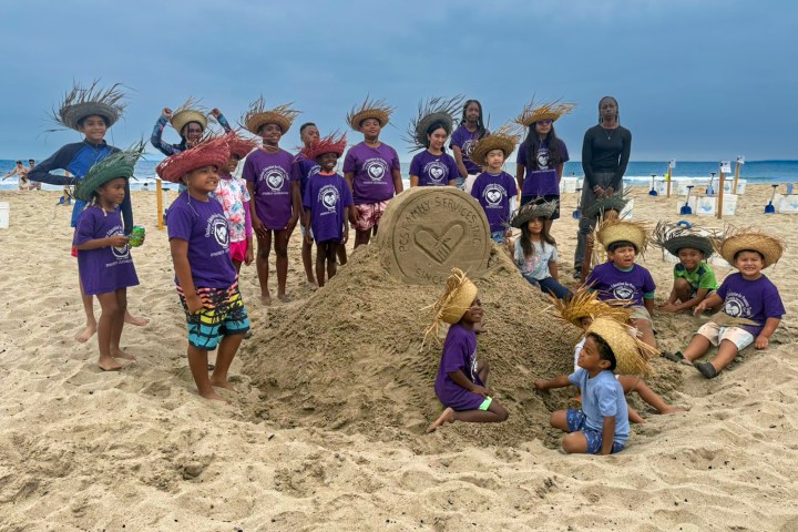 Children participating in sandcastle sculpting activity
