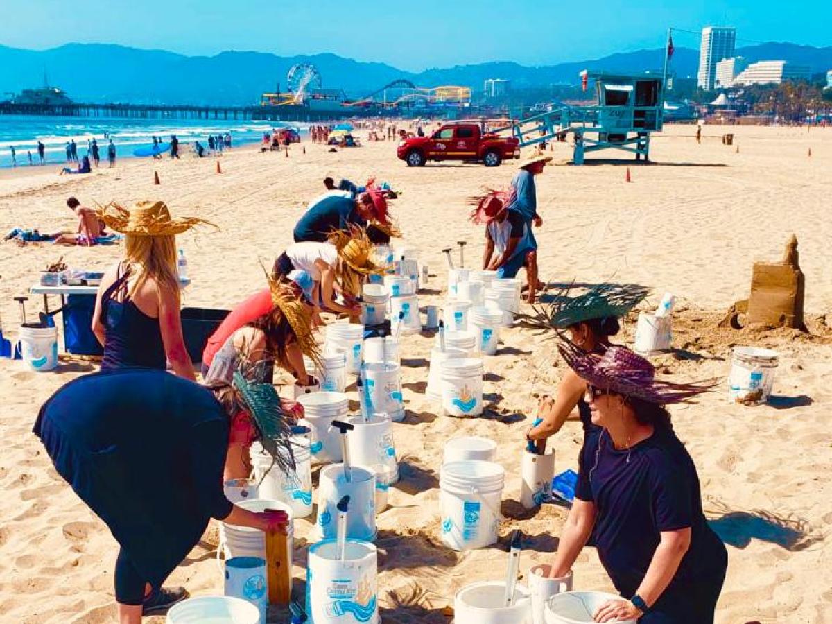a group of people sitting at a beach building sand castles