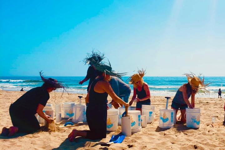 a group of people partaking in a corporate tour sand castle building