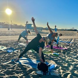 a group of people doing yoga at an outdoor team building event