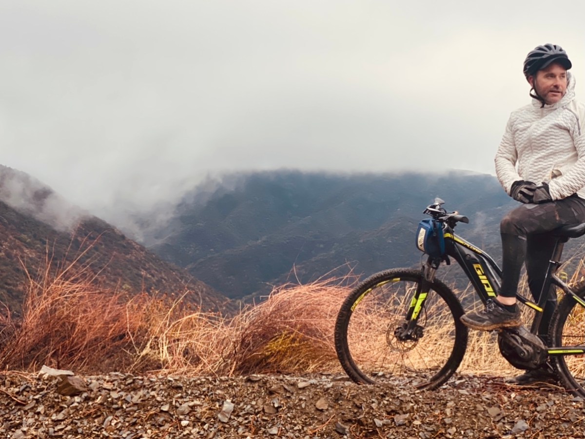 a man riding a bike down a dirt road