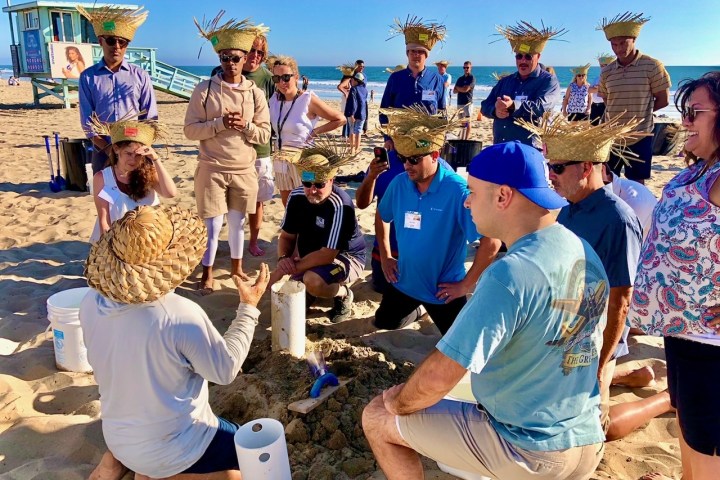 a group of people building sand castles for an la team building activity