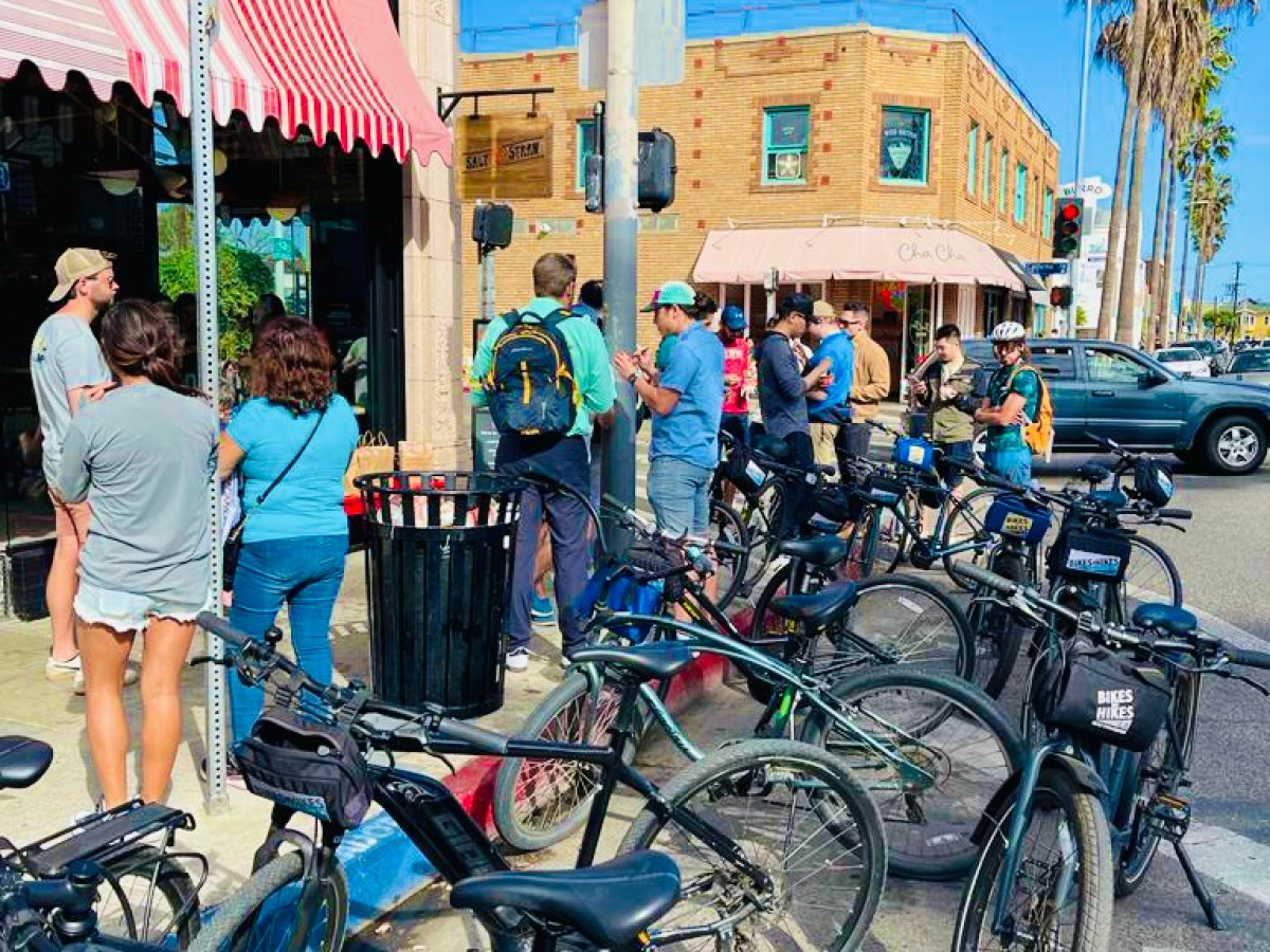 a group of people standing on the venice boardwalk on a los angeles tour