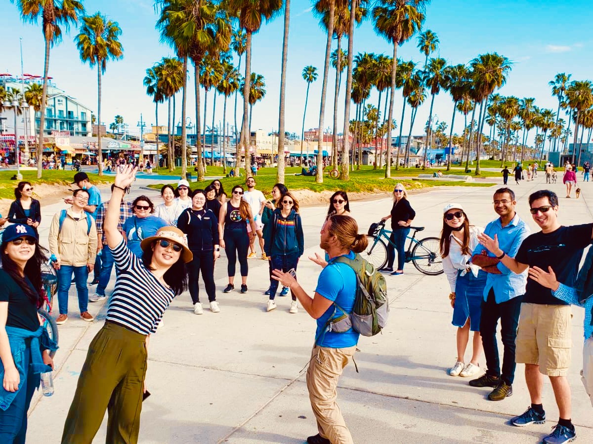 a group of people posing for the camera on the venice boardwalk on an la tour