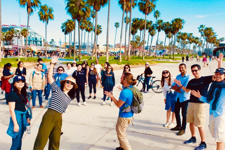 a group of people posing for the camera on the venice boardwalk on an la tour