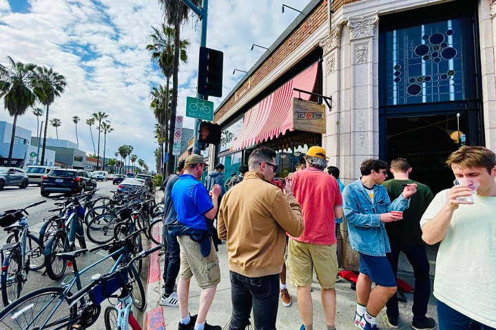 a group of people walking down the street on an la bike tour in venice ca