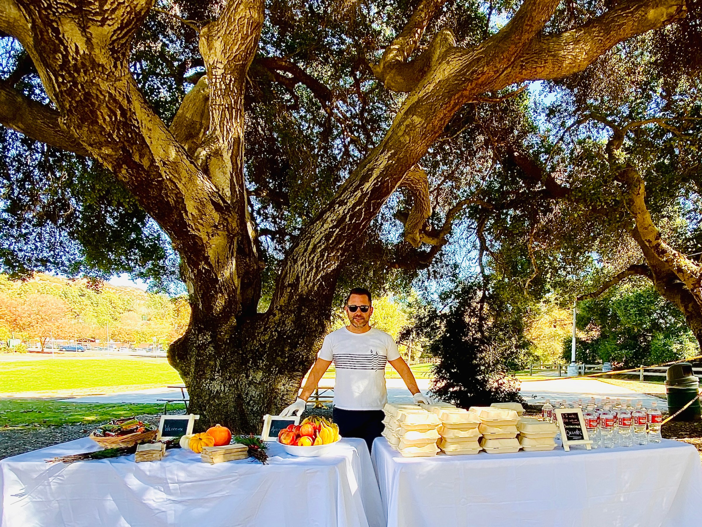 a person stands behind a table with a picnic lunch on a los angeles tour