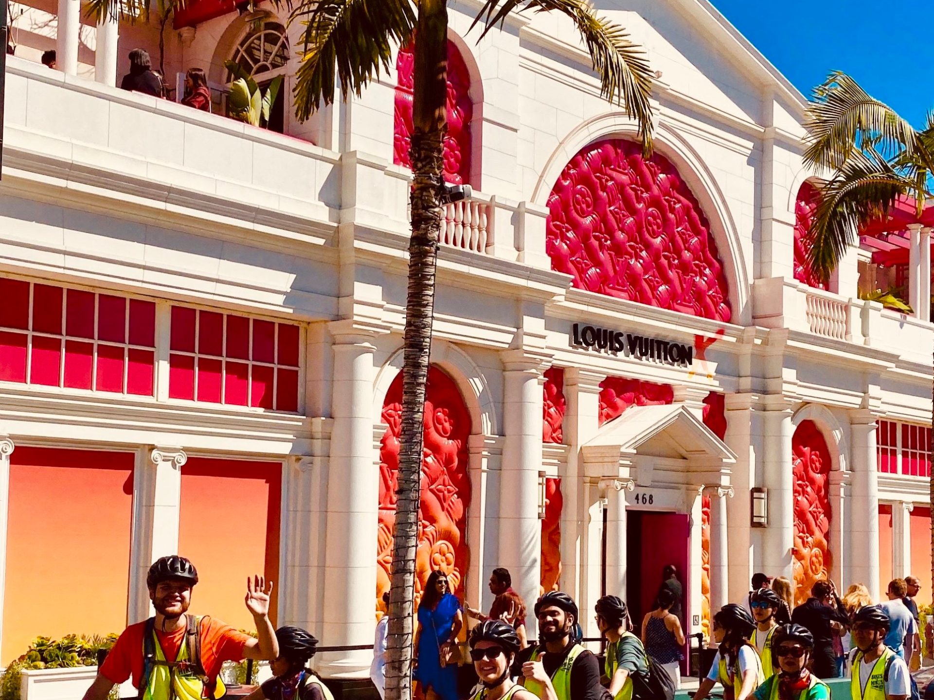 a group of people on a bike tour in front of louis vuitton