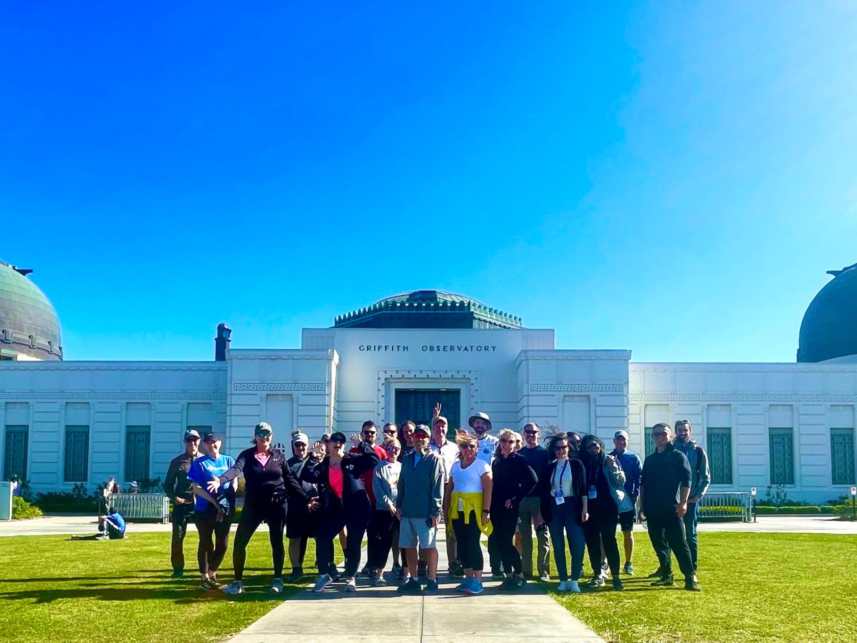 a group of people standing in front of the griffith observatory on a private tour