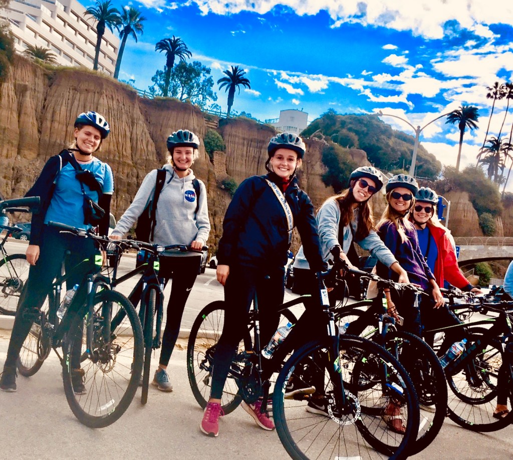 a group of people riding on the back of a bicycle