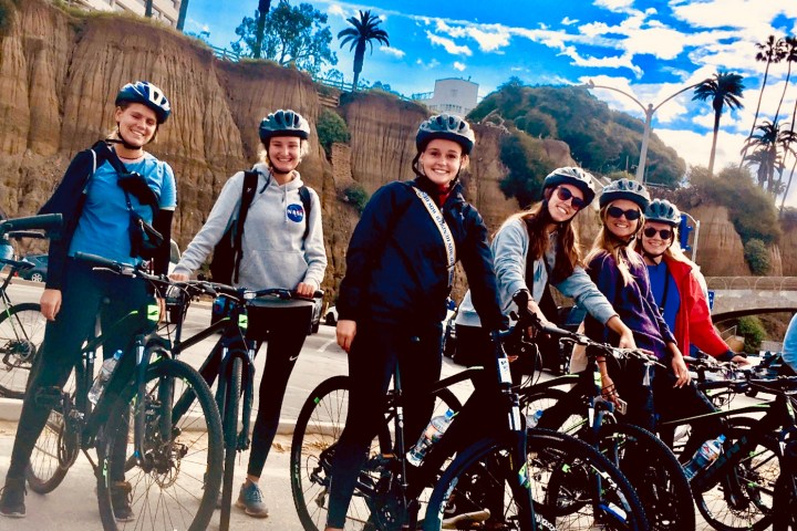 a group of people riding on the back of a bicycle