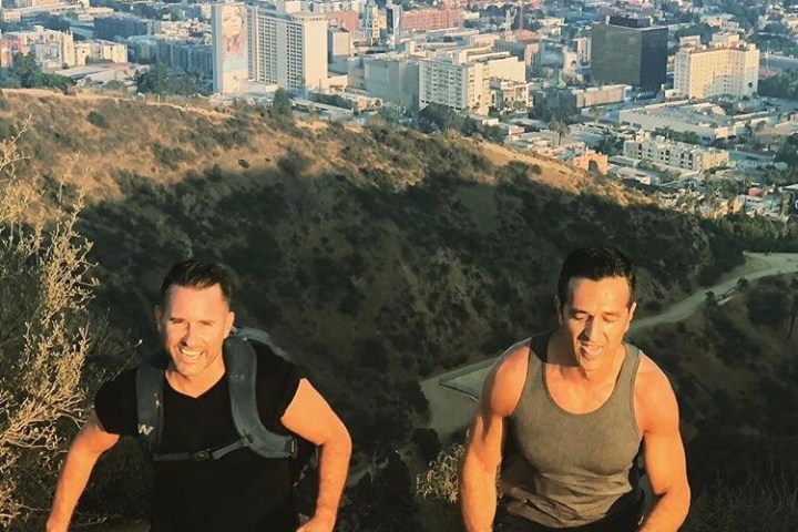 Two runners hike the Runyon Canyon Trail in West Hollywood, California at sunset