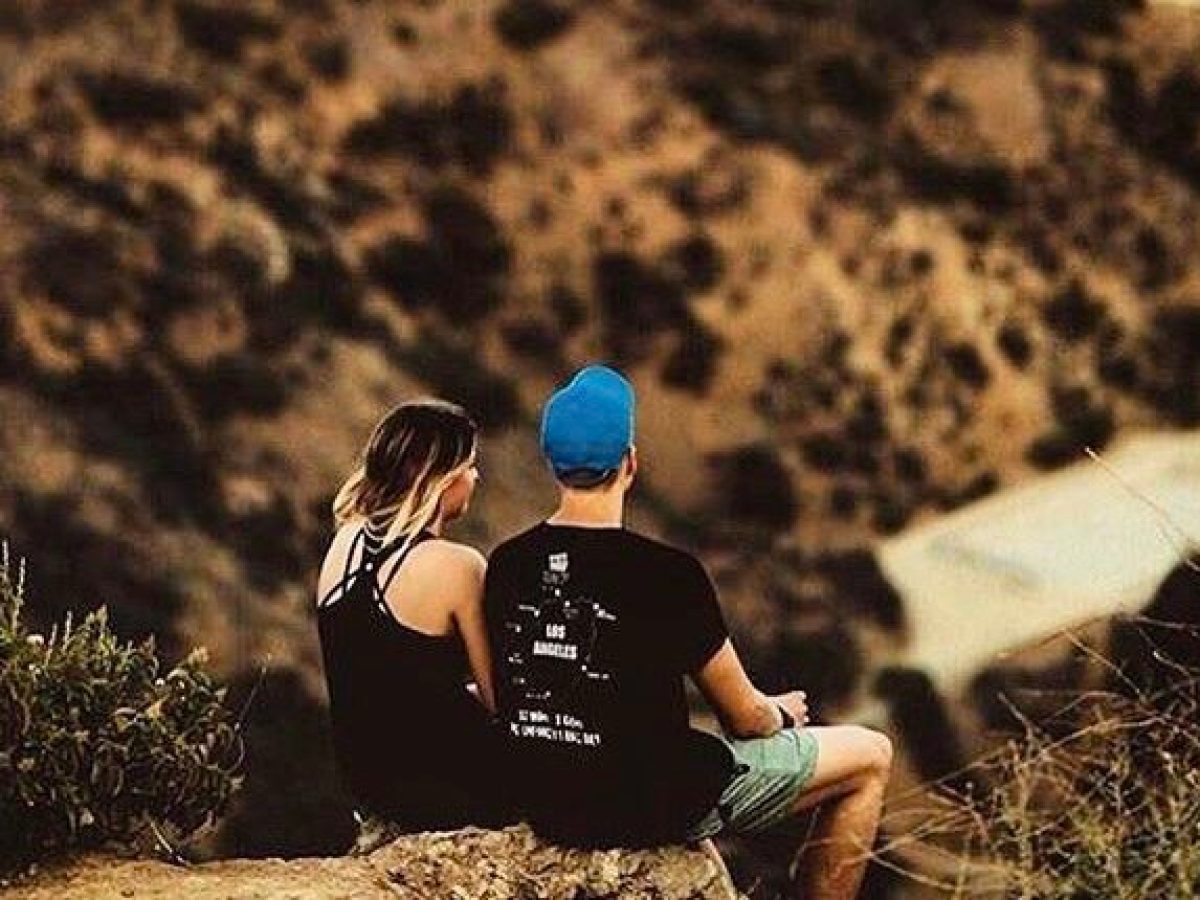 A couple sits looking at Los Angeles from the Runyon Canyon Trail in West Hollywood, California
