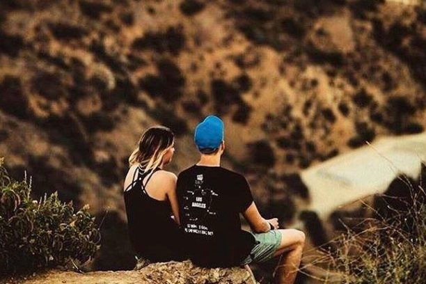 A couple sits looking at Los Angeles from the Runyon Canyon Trail in West Hollywood, California