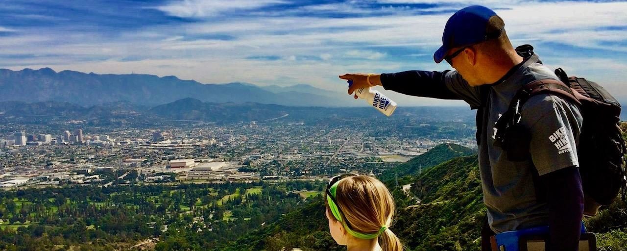 a man standing next to a little girl on a mountain