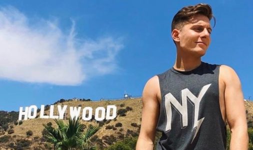 young man standing under the hollywood sign