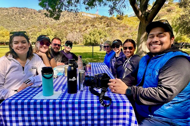 a group of people sitting at a picnic table posing for the camera