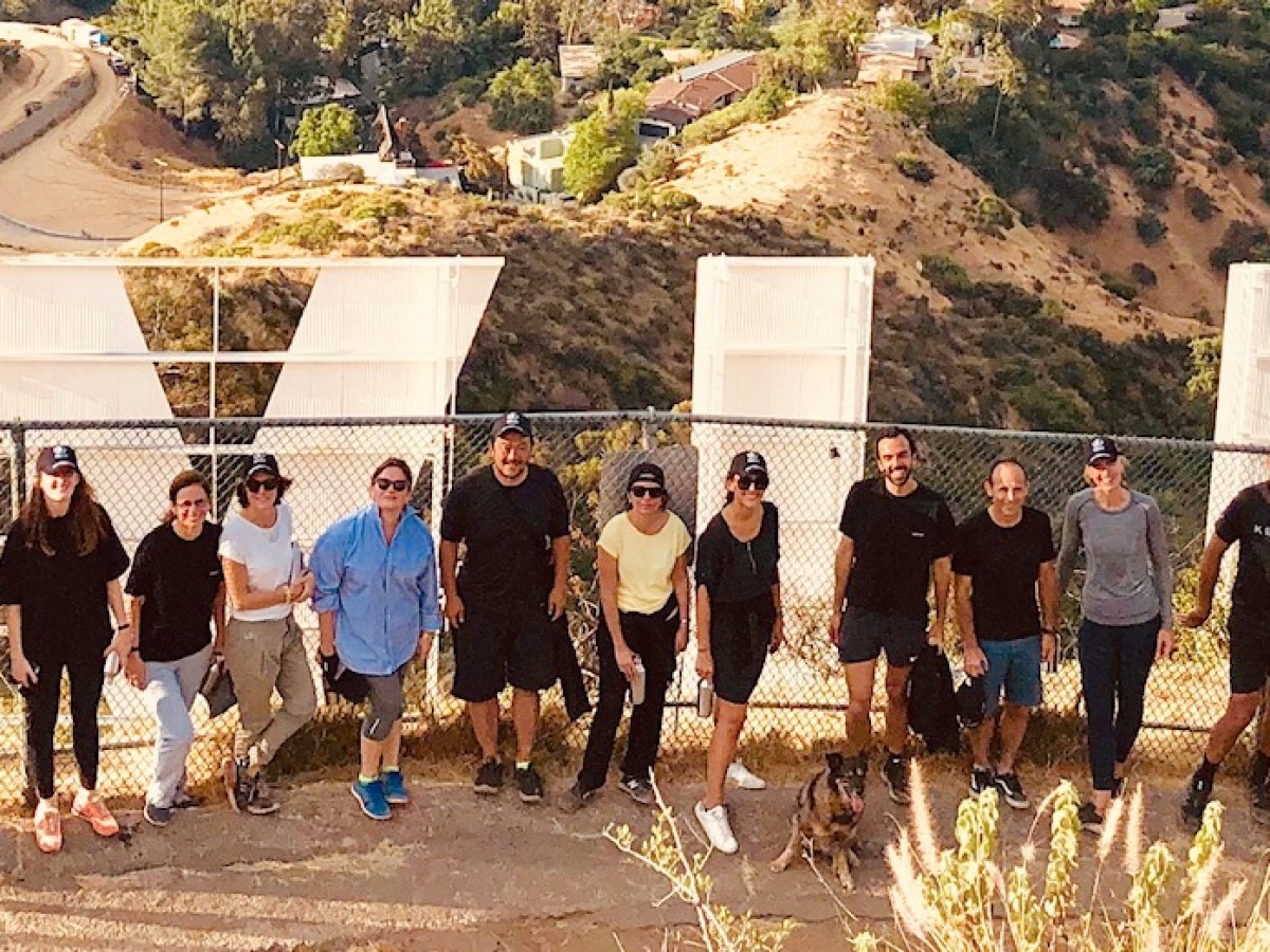 group of hikers behind the hollywood sign on a hollywood hills hike