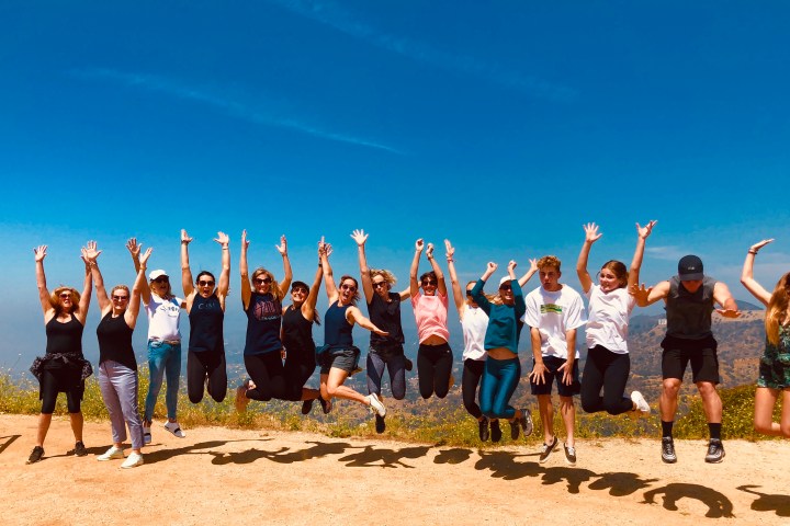 a group of people standing on top of a sandy beach