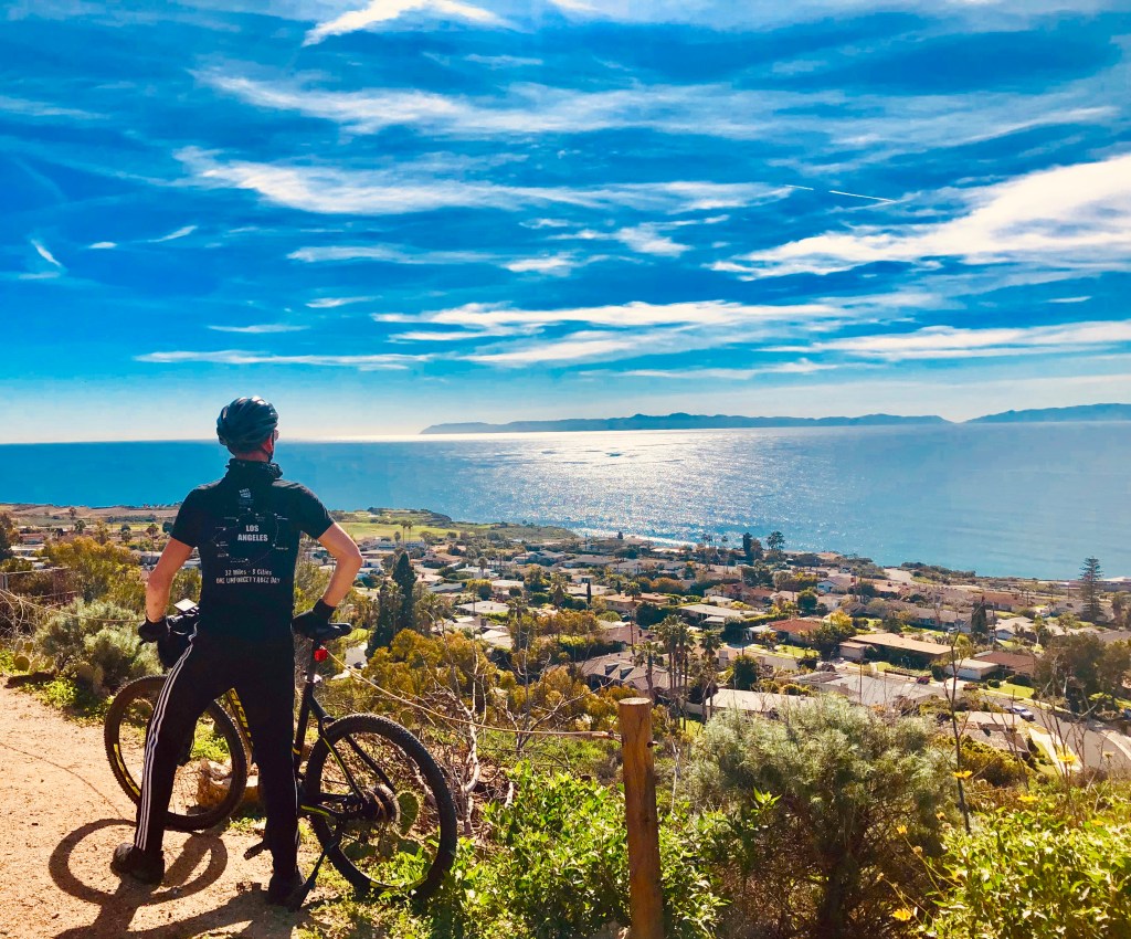 a guide from bikes and hikes la standing next to the pacific ocean