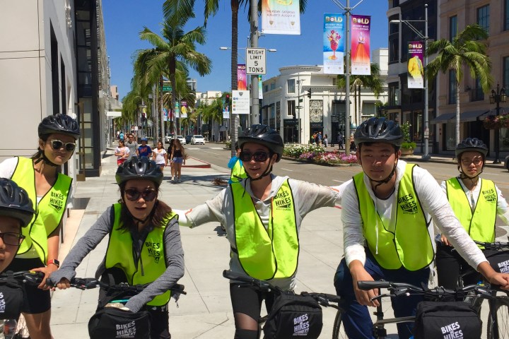 a group of people standing next to a bicycle