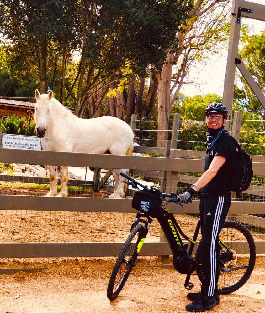 a person riding a horse next to a bicycle