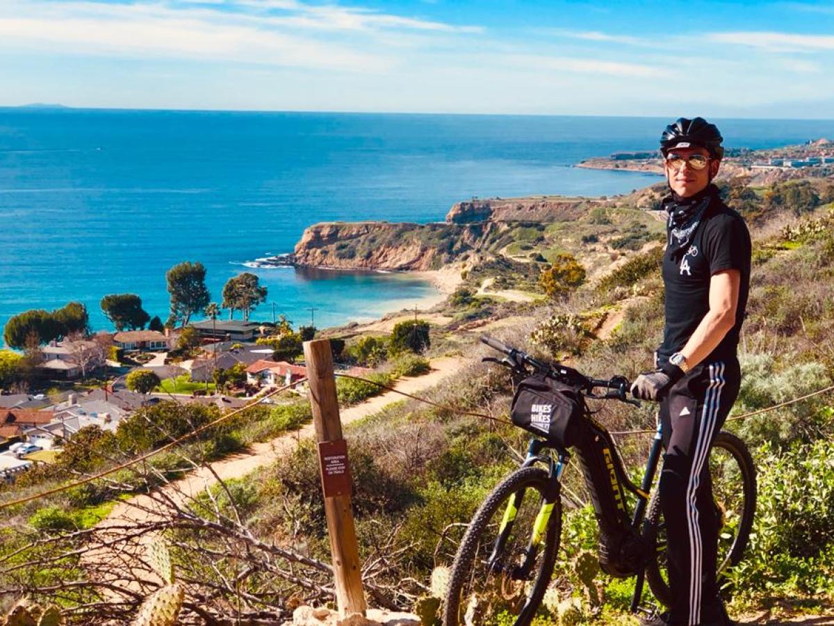a man with a bicycle near a body of water