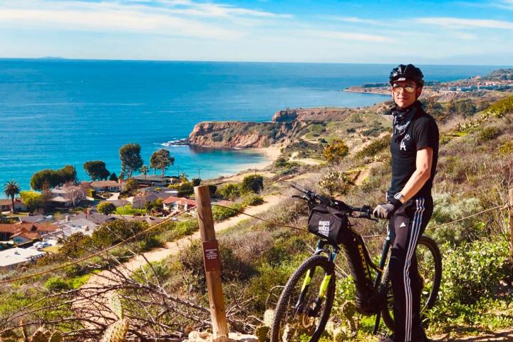 a man with a bicycle near a body of water
