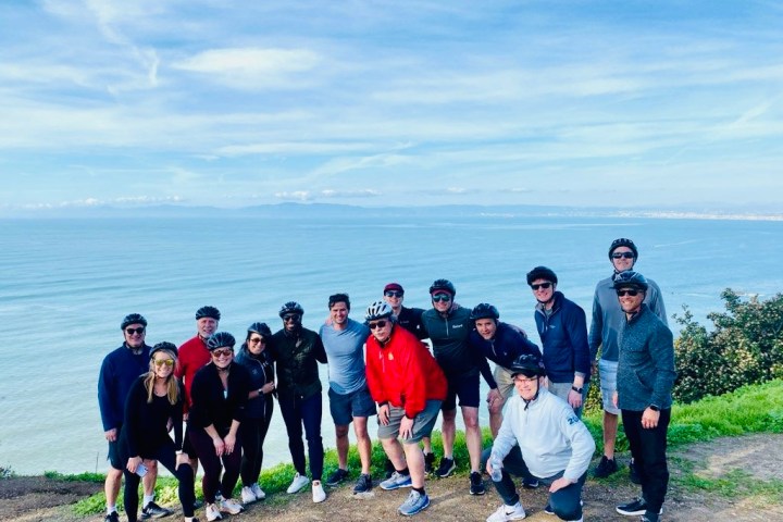 a group of people standing on a beach posing for the camera