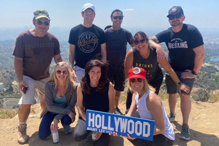 group posing with a sign on a hollywood sign hike