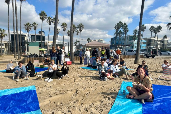 a group of people sitting at a beach