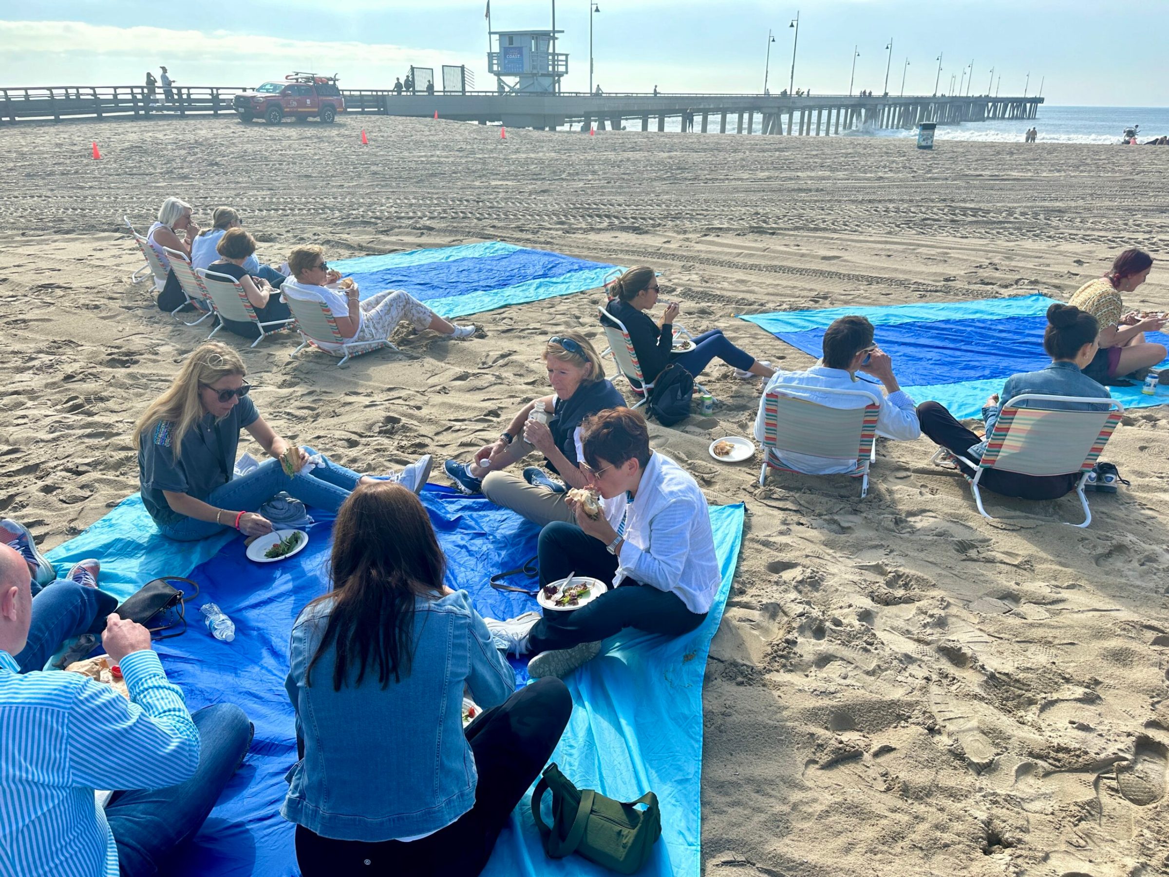 a group of people sitting at a beach