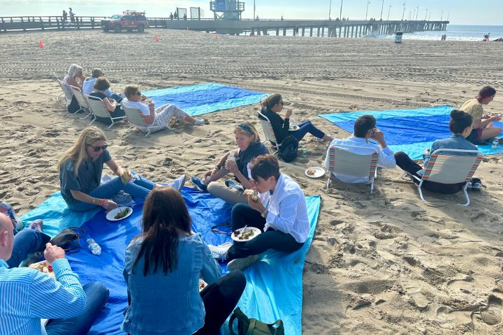 a group of people sitting at a beach