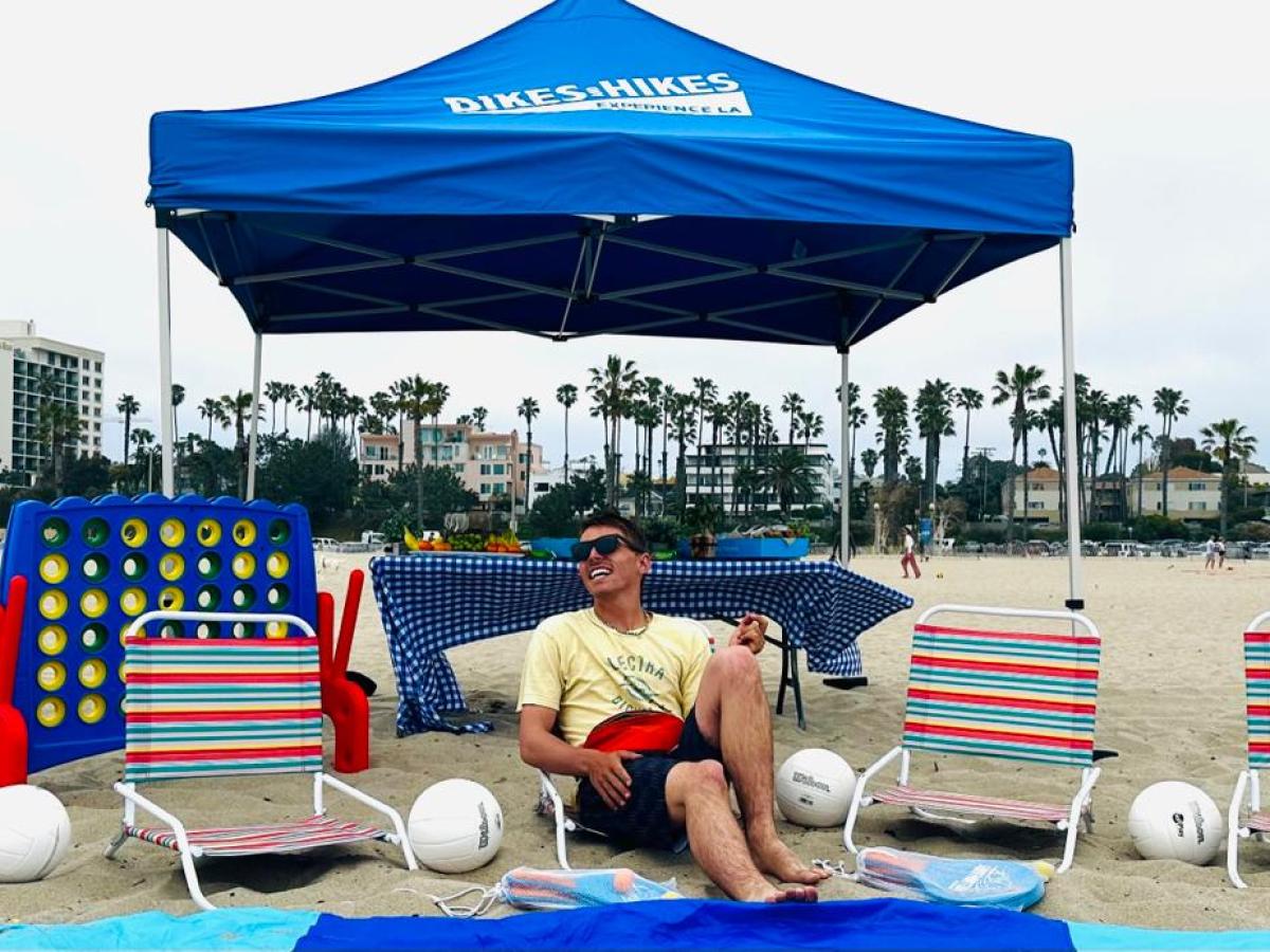 a person sitting in a chair with a blue umbrella