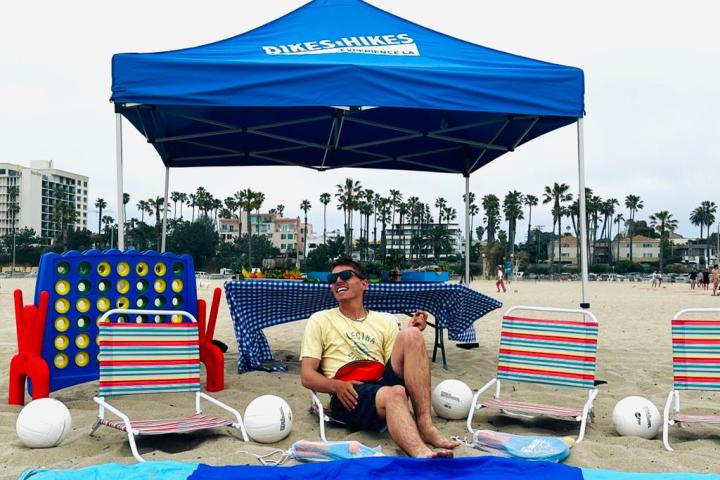 a person sitting in a chair with a blue umbrella