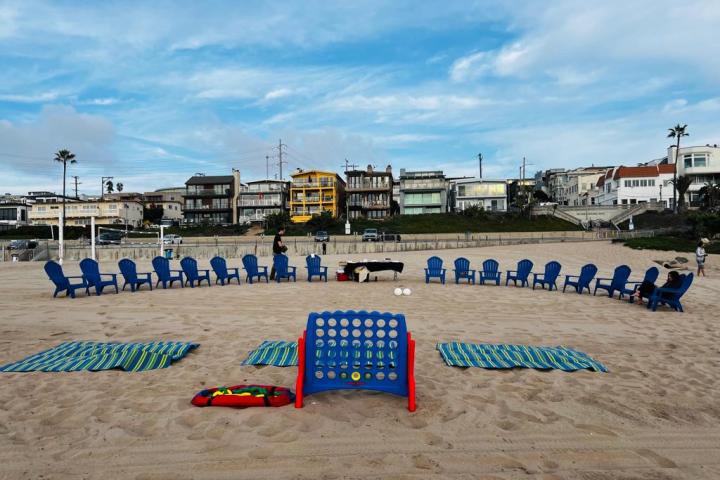 a group of people sitting on top of a sandy beach