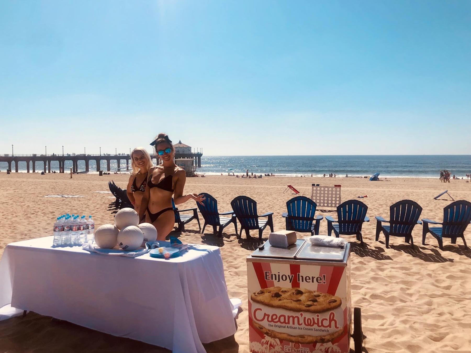 table with water, volleyballs, and ice cream on beach