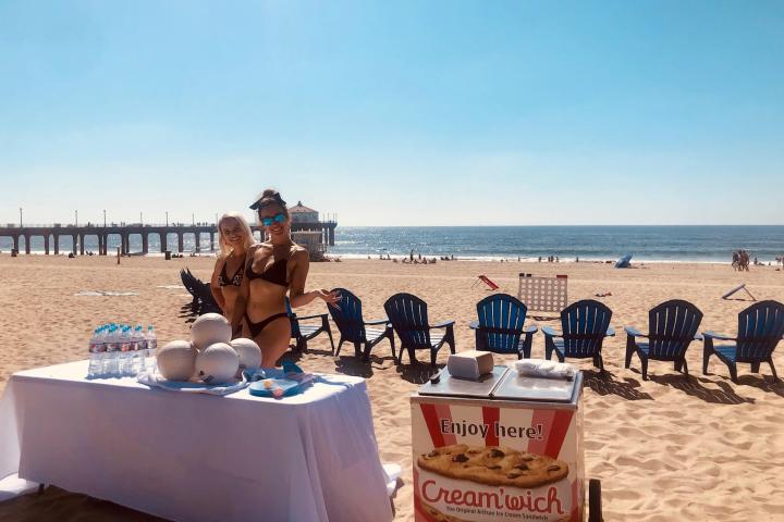 table with water, volleyballs, and ice cream on beach