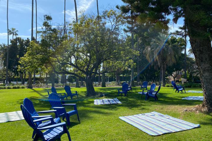 a couple of lawn chairs sitting on top of a bench in a park