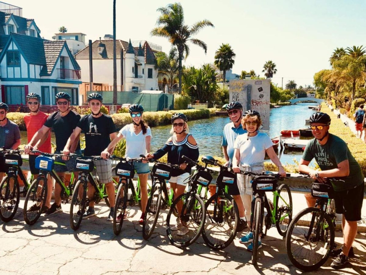 a group of people and bicycles on a bike tour of the venice canals