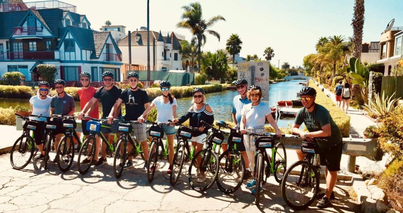 a group of people and bicycles on a bike tour of the venice canals