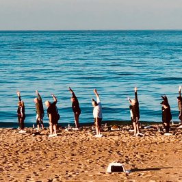 a group of people standing on top of a sandy beach