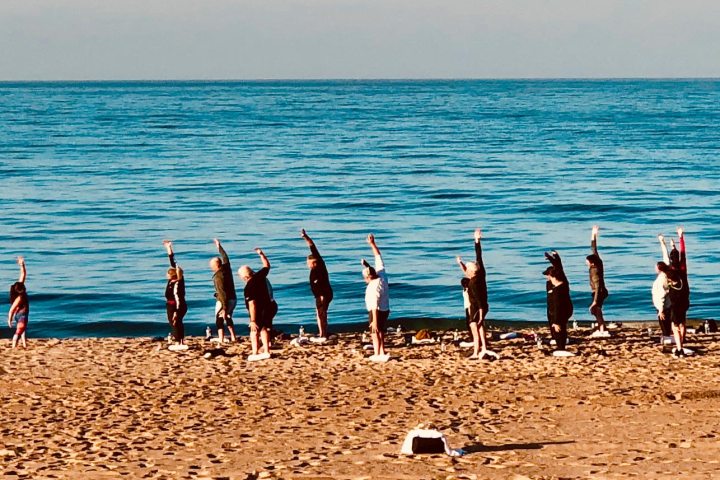 a group of people standing on top of a sandy beach