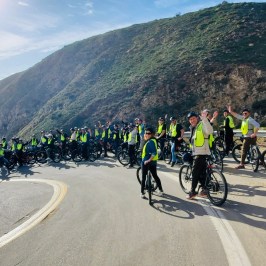 a group of people riding bikes on a mountain road