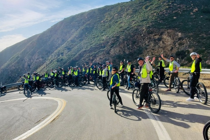 a group of people riding bikes on a mountain road