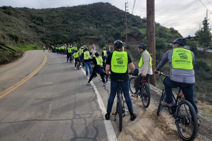 a group of people riding bikes down a dirt road