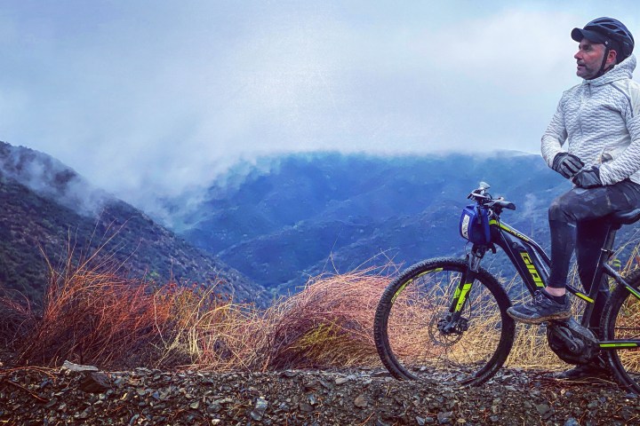 a man riding a bike down a dirt road