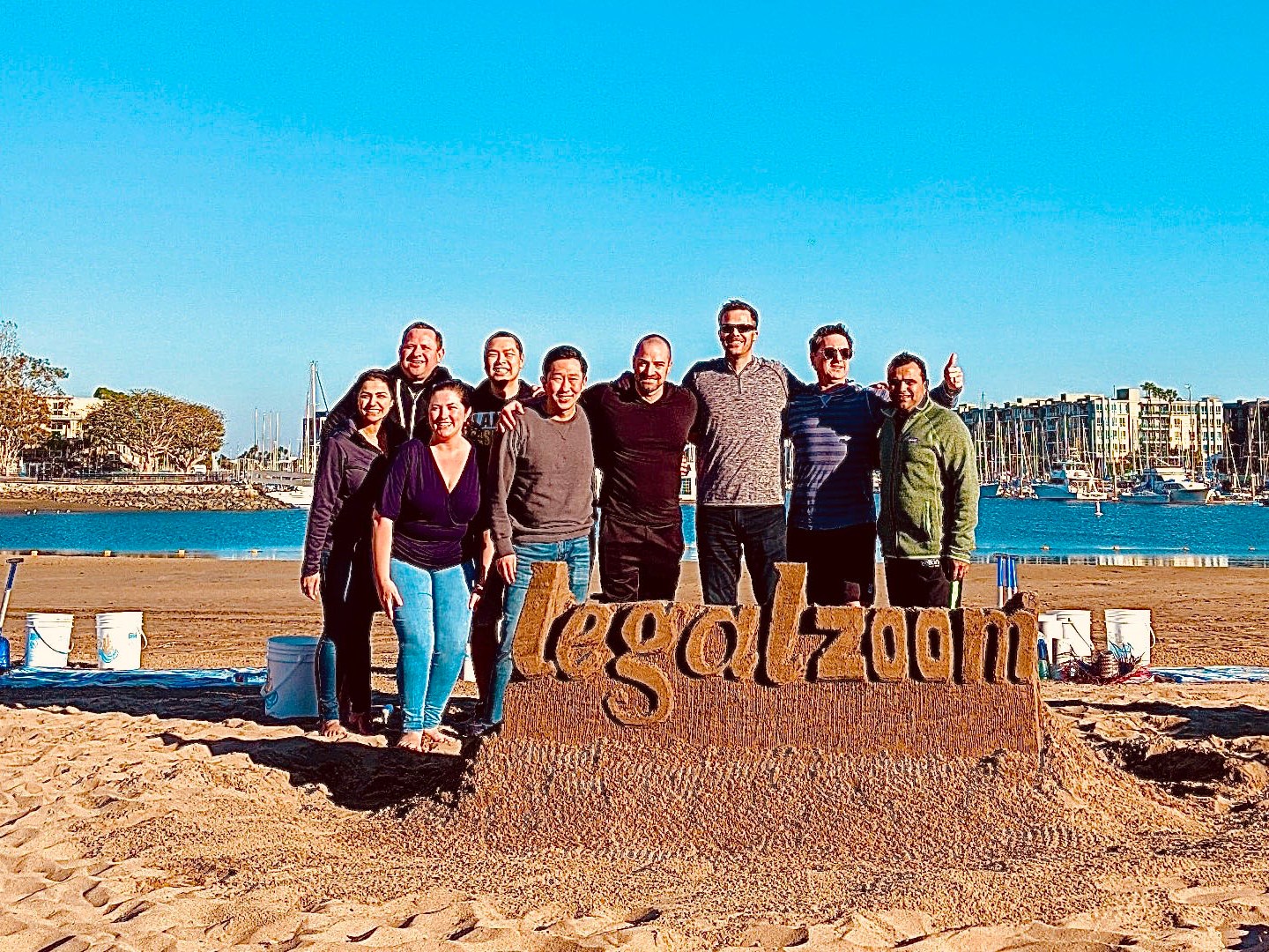 a group of people standing on top of a sandy beach with Cadillac Ranch in the background
